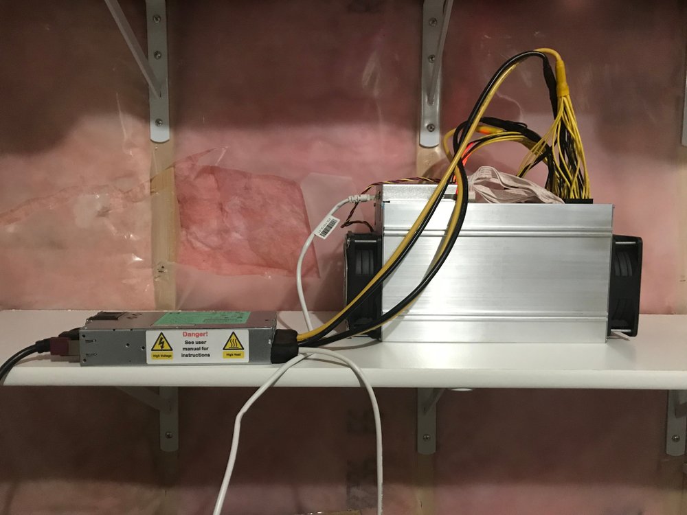 antminer s19 mining bitcoin at home with insulation exposed on wall 