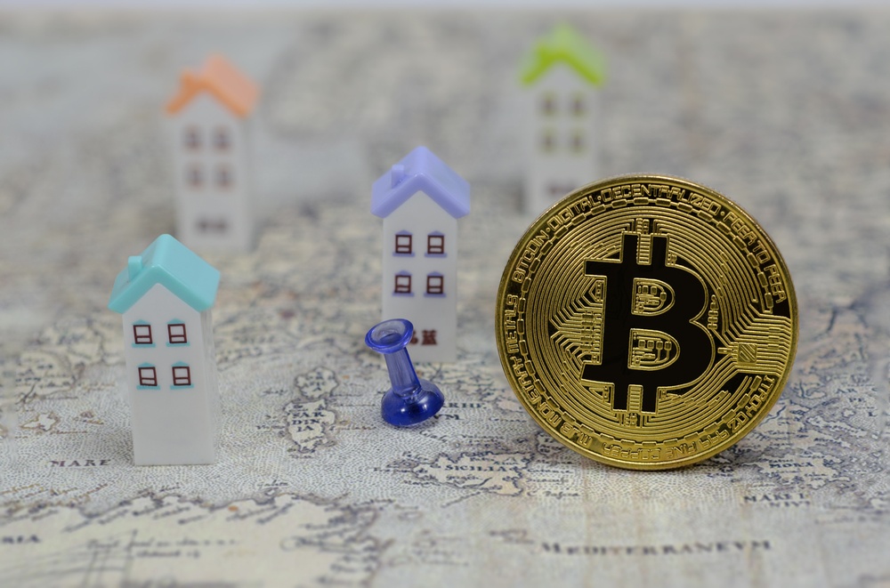 large bitcoin coin with toy houses 