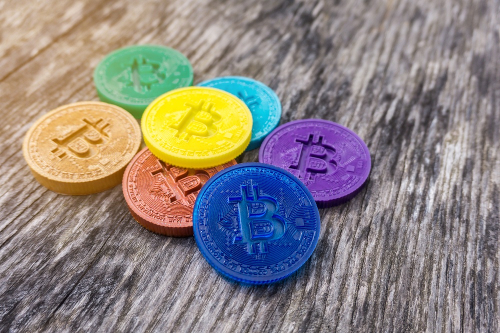 colorful physical bitcoins on wood background 