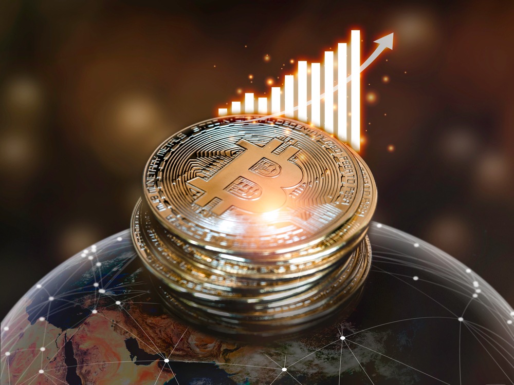 bitcoins sitting on top of globe represents rising global wealth 