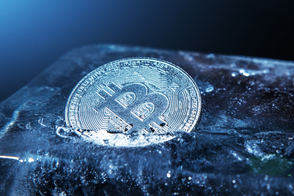 ice cold blue bitcoin frozen in large block of ice 