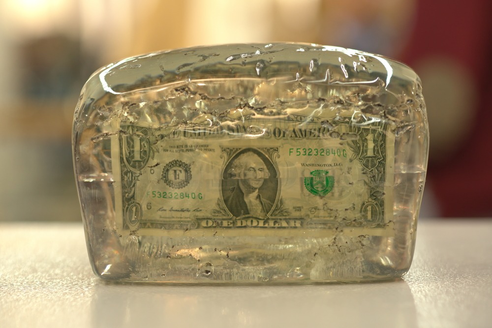 dollar in a melting ice cube 