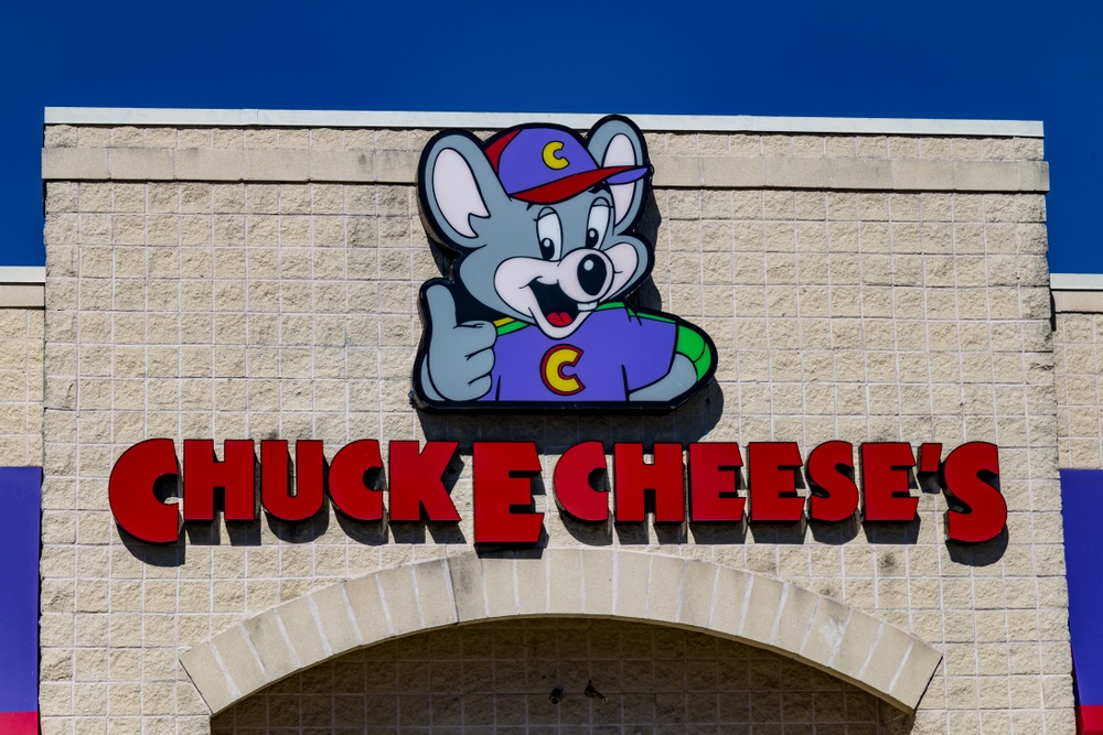 is bitcoin like chuck e. cheese tokens? outside chuck e cheese location with logo on brick wall.  