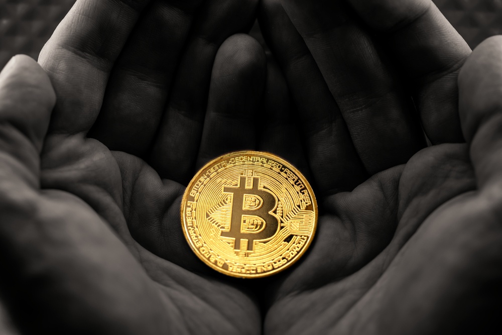 can you buy a physical bitcoin? physical gold bitcoin contrasted in black and white hands 