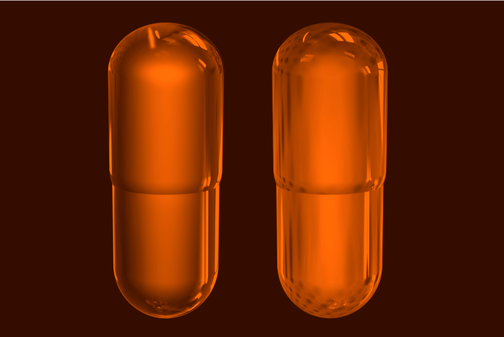 bitcoin orange pill. Two brigh-colored and transparent orange pills on a dark background to represent the orange pill concept in bitcoin 