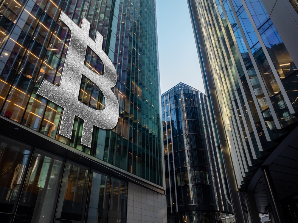 Silver glitter bitcoin logo on the face of financial district building 