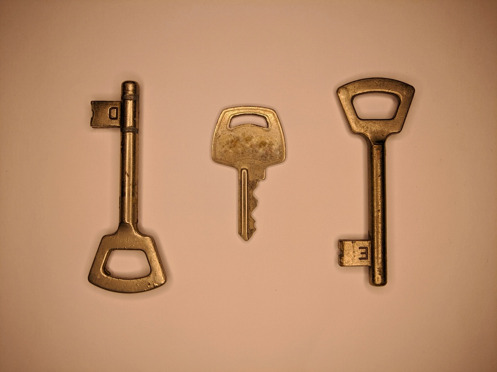 Two old style skeleton keys and one modern key representing 2 of 4 collaborative custody of bitcoin keys 