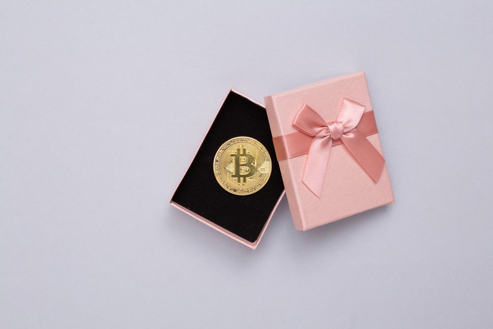 how to gift bitcoin. bitcoin being unwrapped from pink gift box with pink bow 