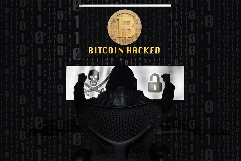 Bitcoin,hacked,with,a,three-screen,computer.,dark,background cloaked man in ergonomic computer chair looking at screen with bitcoin logo that says, "Bitcoin Hacked"