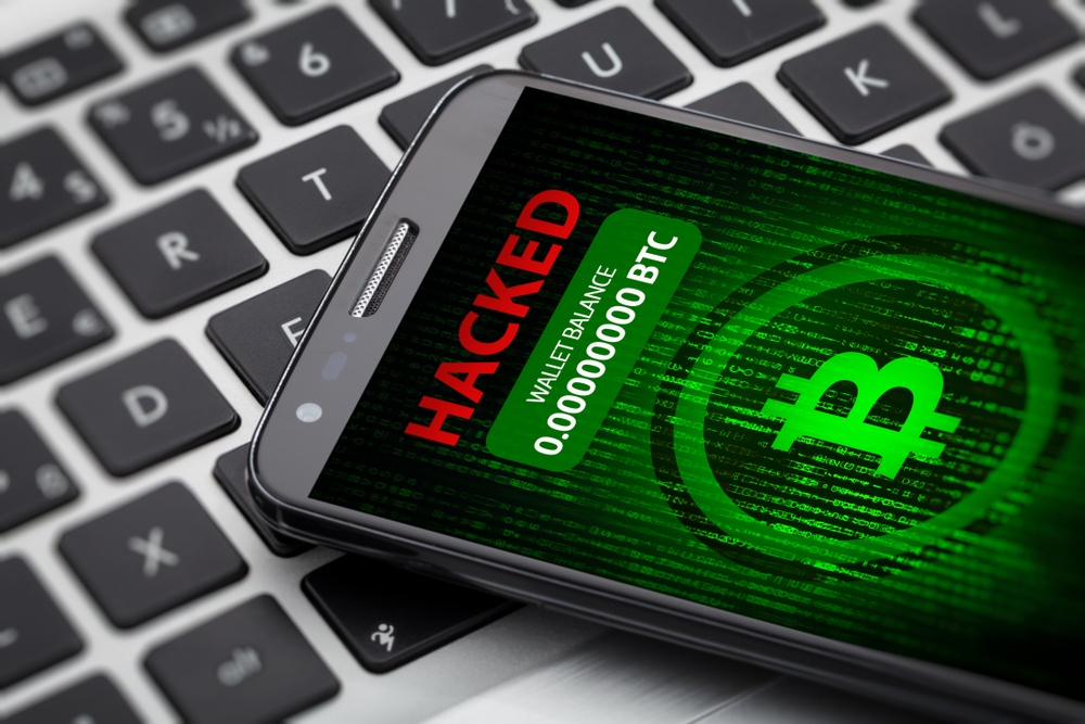 smartphone with bitcoin logo and red lettering,  "Hacked" with 0.00 wallet balance