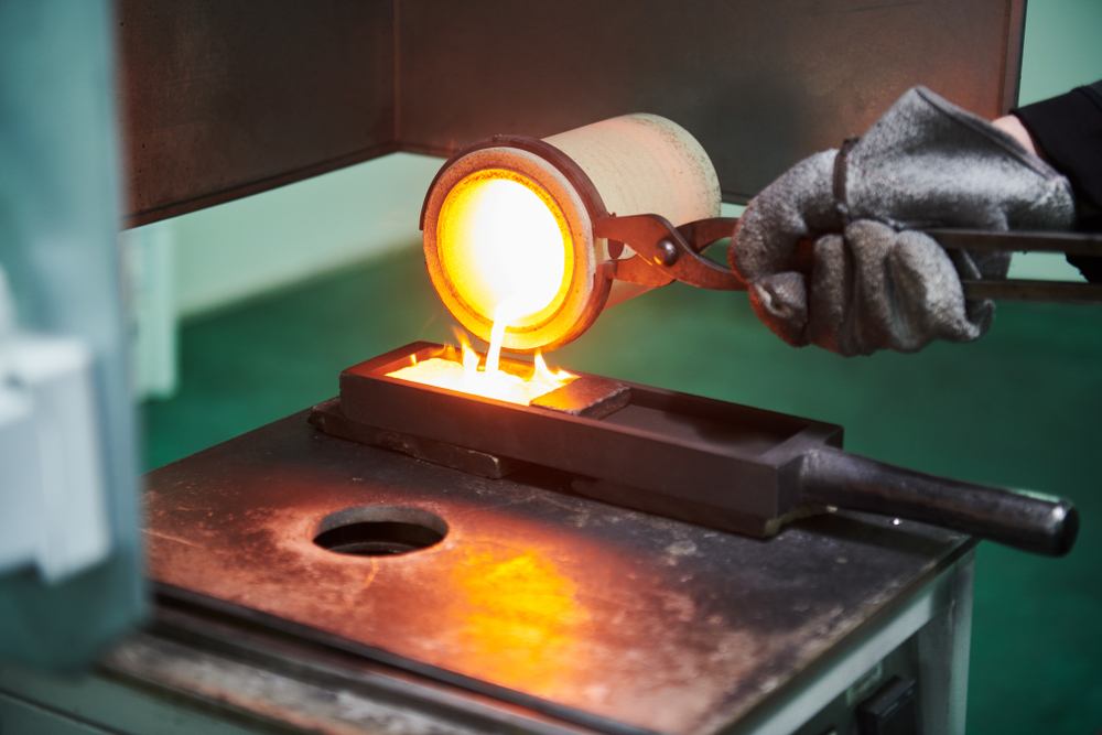 pouring liquid gold into gold ingot 