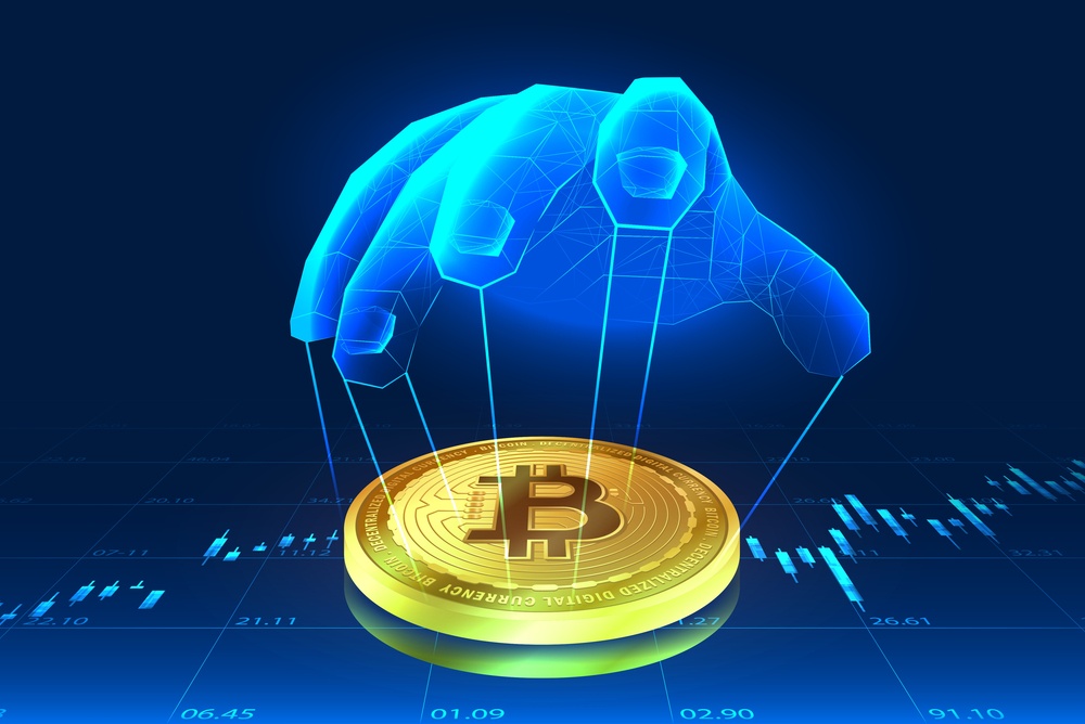 An illustration of a bitcoin on top of graphs. A polygon hand is being used to control the coin via strings. 