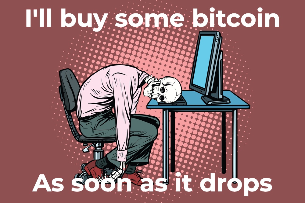 A cartoon image with a skeleton in business clothes collapsed over his computer keyboard, with text that says "I 'll buy some bitcoin as soon as it drops"