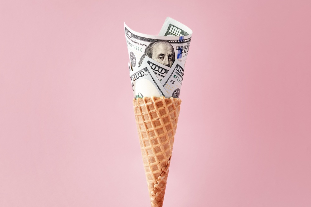 Melting-dollar-ice-cream-cone waffle ice cream cone with 0 bills folded like ice cream on pink background