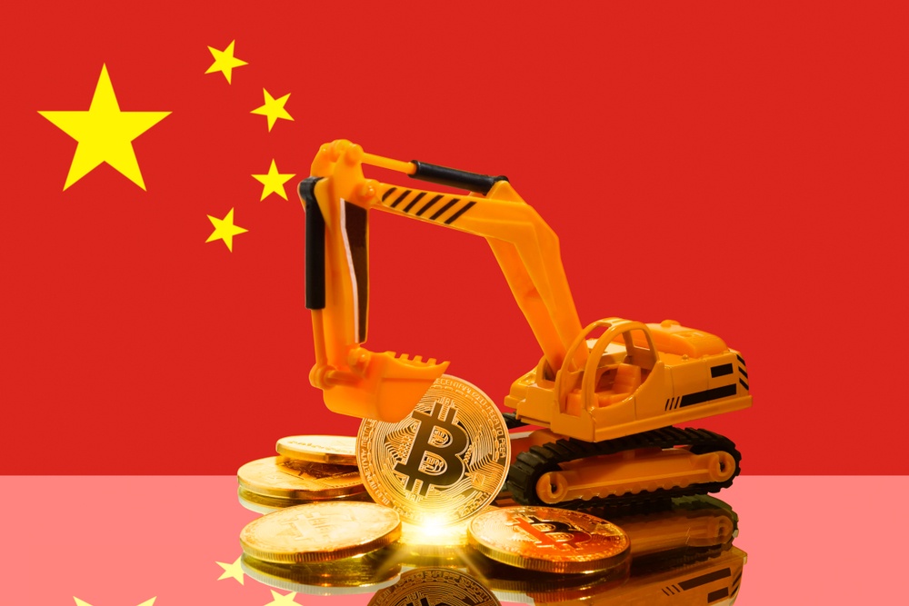 A plastic toy digger with physical bitcoins, in front of the Chinese flag 