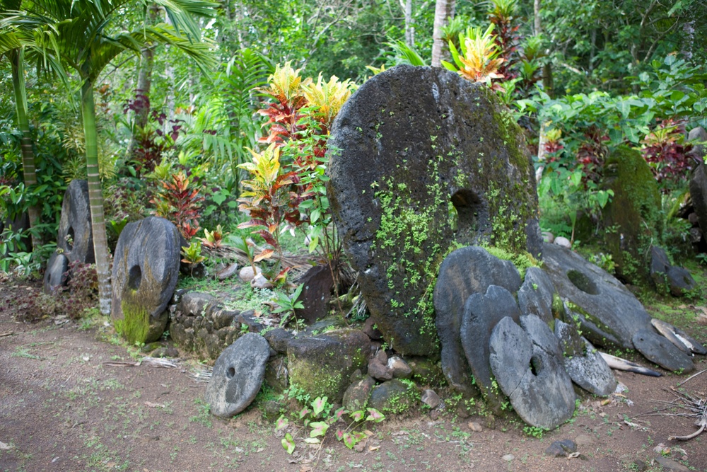 ancient yap island money large stones covered with moss, stacked together in the jungle 