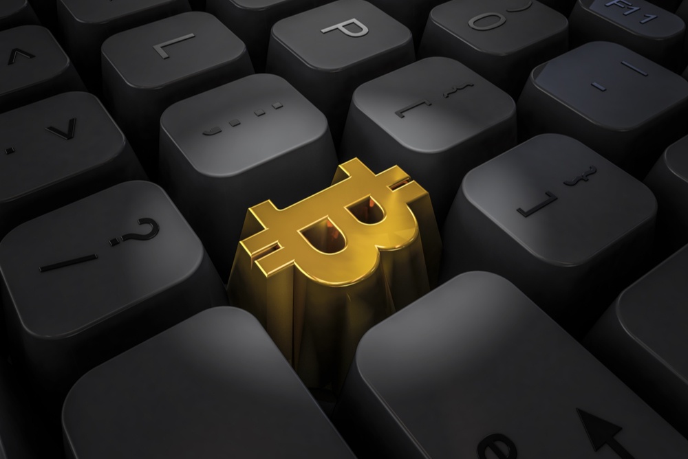 shiny gold bitcoin symbol on black keyboard 