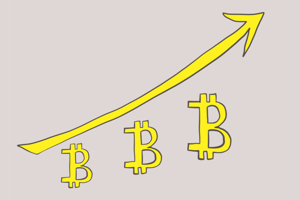 bitcoin symbol written in casual script font growing in size three times with arrow trending upward 