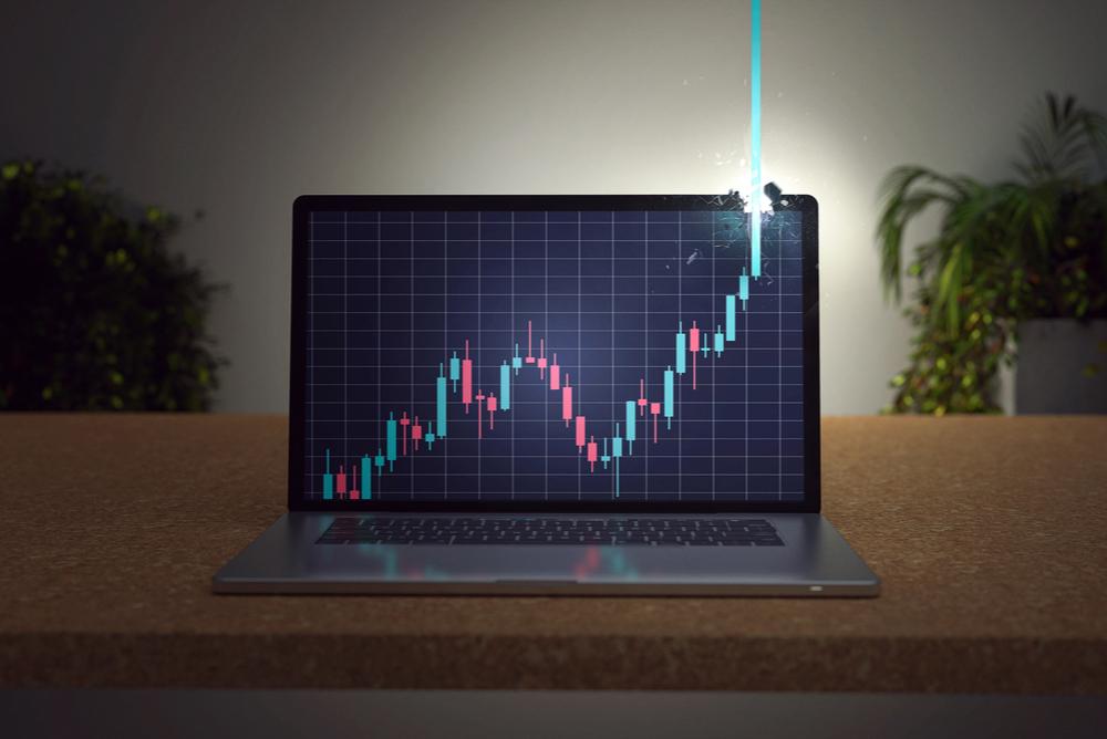 bitcoin price chart with green candle bursting through the top of a laptop screen. bitcoin all time high 