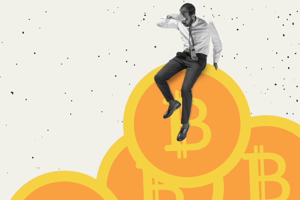 black and white image of a man sitting on top of orange colored bitcoins 