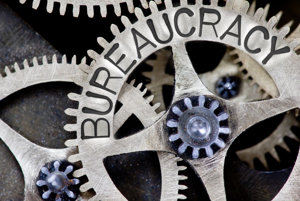 slow gears of government bureaucracy. gears with  "bureaucracy" written on them