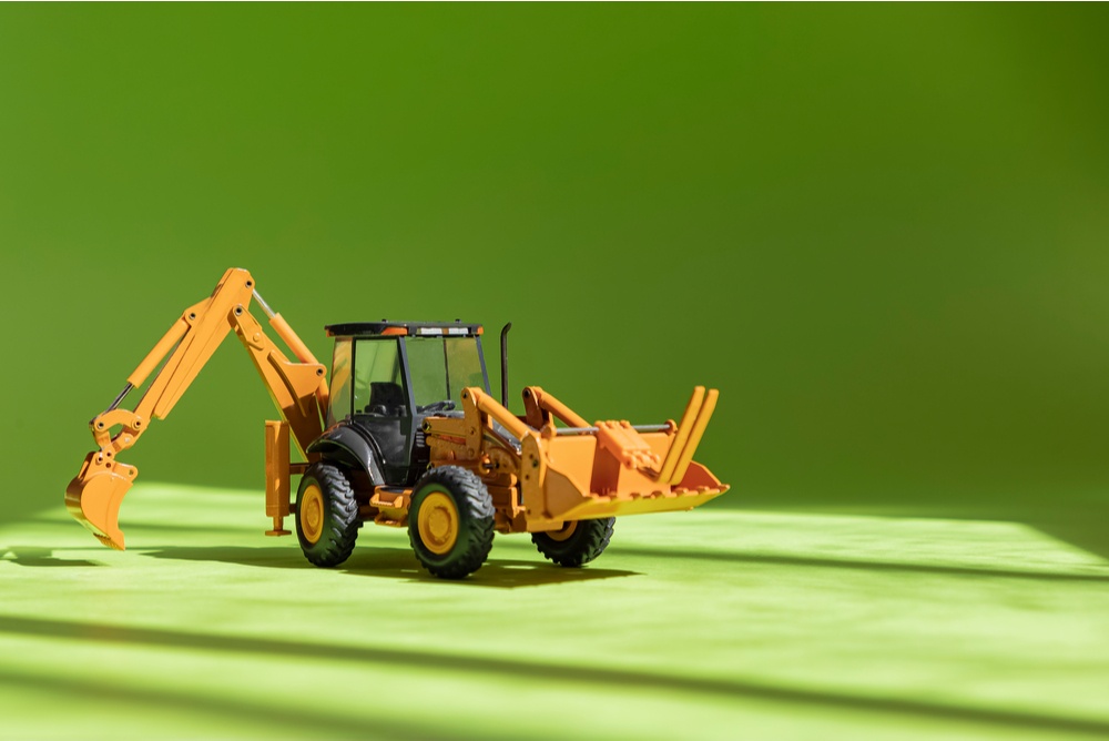 backhoe loader with excavator arm on green background. mining for green fiat cash money. fiat mining 